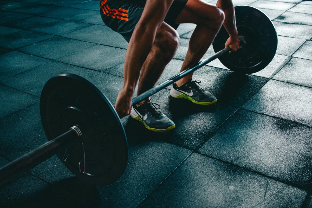Pytania i Odpowiedzi 1 Man performing a deadlift exercise in a gym, demonstrating strength and fitness.